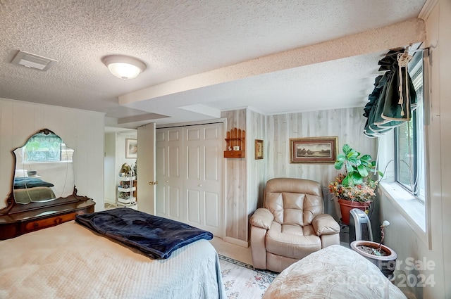 bedroom with a closet, multiple windows, and a textured ceiling