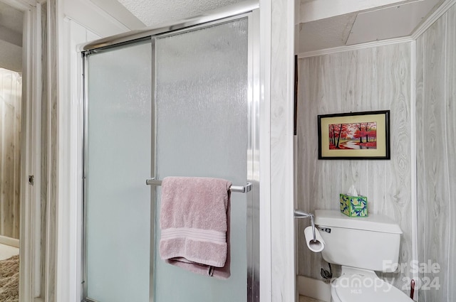 bathroom featuring walk in shower, a textured ceiling, and toilet