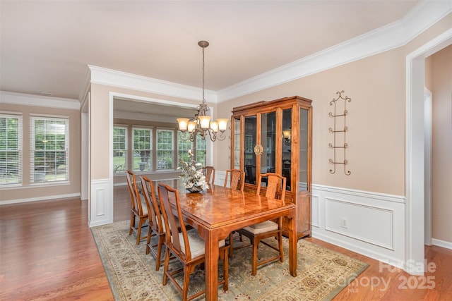 dining room featuring an inviting chandelier, crown molding, and hardwood / wood-style floors