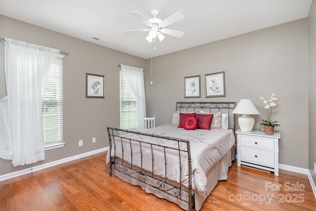 bedroom featuring multiple windows, ceiling fan, and light hardwood / wood-style flooring