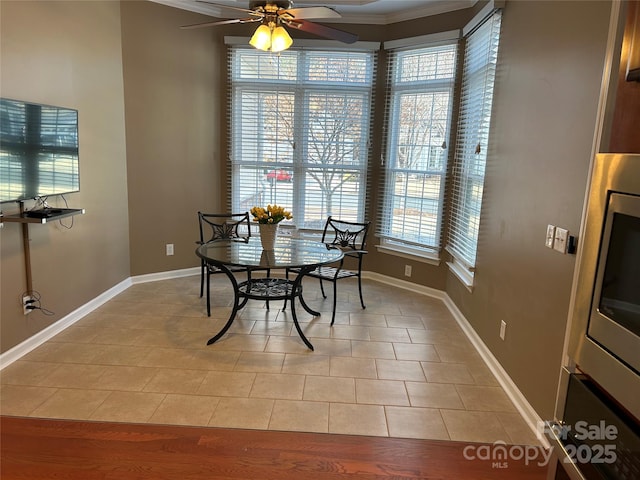 dining area with crown molding, light tile patterned flooring, and ceiling fan