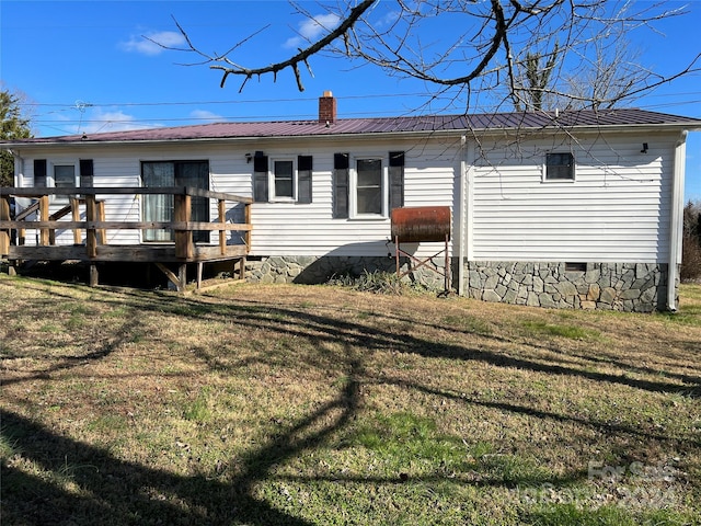 back of house with a lawn and a deck