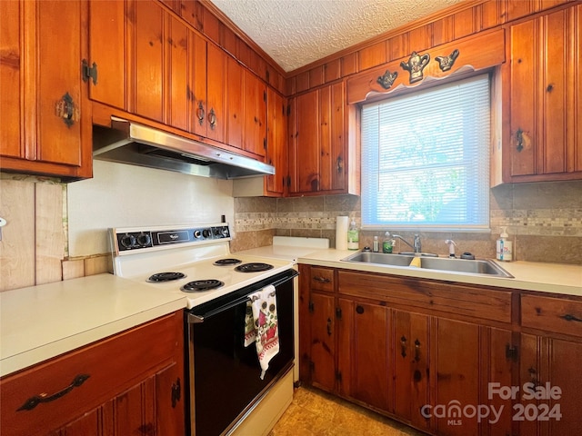 kitchen featuring a textured ceiling, backsplash, white range with electric cooktop, and sink