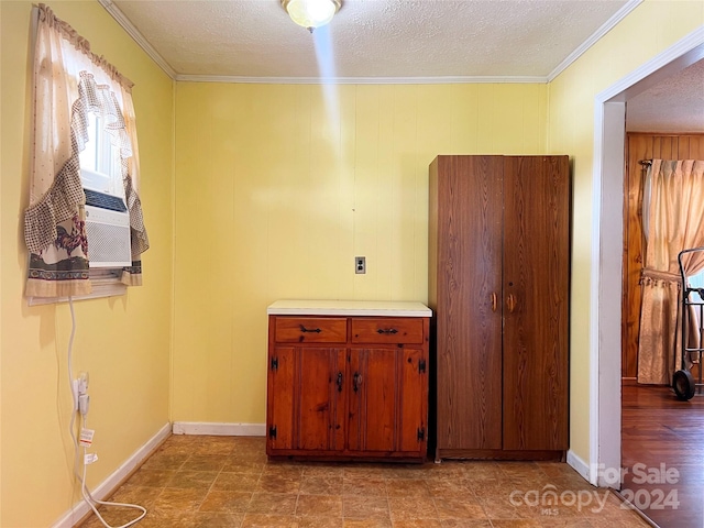 interior space featuring a textured ceiling and ornamental molding