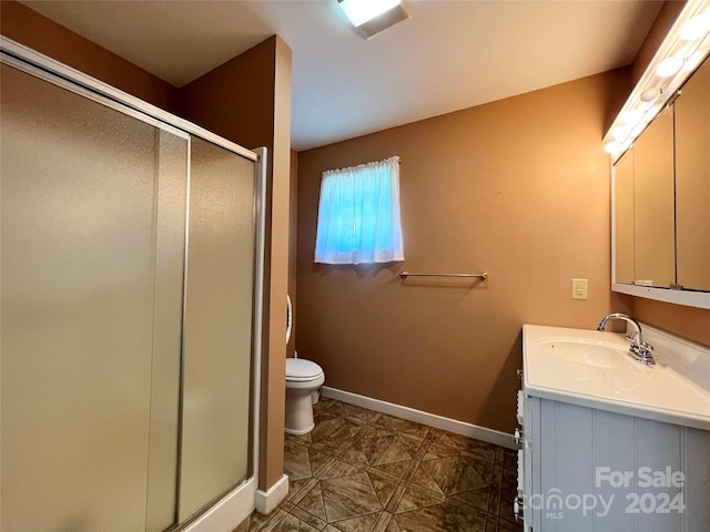 bathroom with vanity, toilet, and a shower with shower door