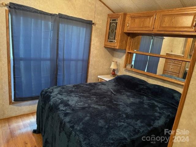 bedroom featuring lofted ceiling and light hardwood / wood-style floors