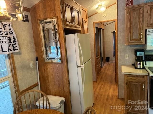 kitchen featuring light hardwood / wood-style floors and white fridge