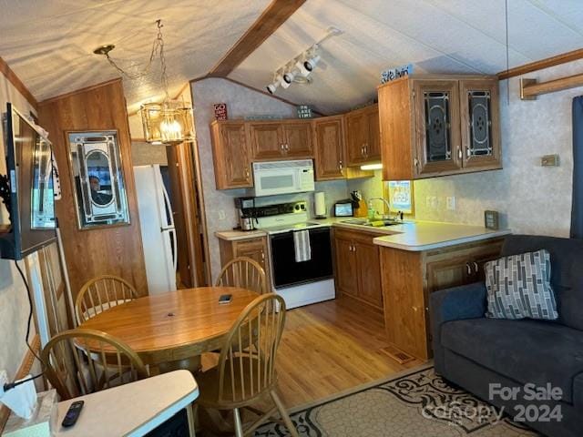 kitchen with white appliances, light wood-type flooring, kitchen peninsula, sink, and lofted ceiling