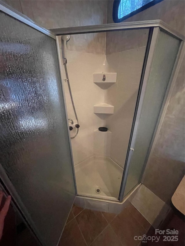 full bathroom featuring a shower stall and tile patterned floors