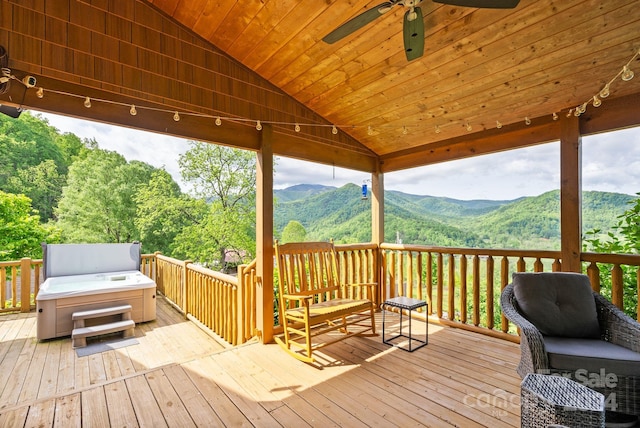 deck featuring a hot tub, ceiling fan, and a mountain view