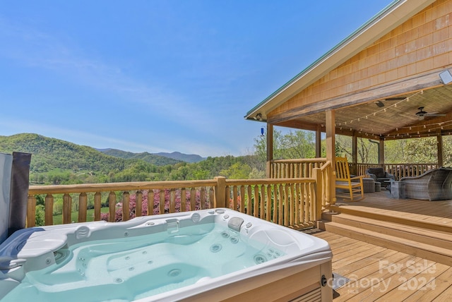 wooden deck with a hot tub and a mountain view