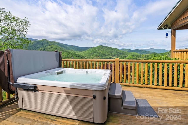 wooden deck featuring a mountain view and a hot tub