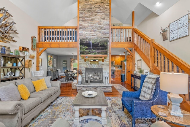 living room featuring high vaulted ceiling, wood-type flooring, and a stone fireplace