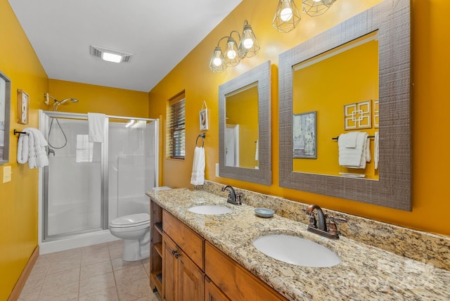 bathroom with vanity with extensive cabinet space, dual sinks, toilet, a shower with shower door, and tile flooring