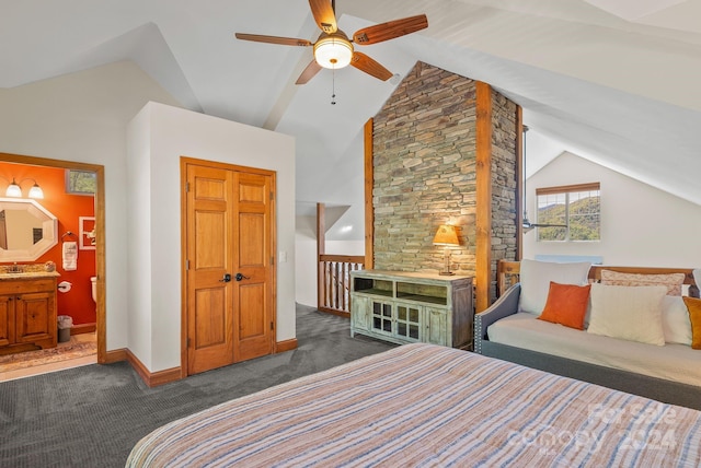 bedroom featuring vaulted ceiling, dark carpet, ensuite bath, and ceiling fan