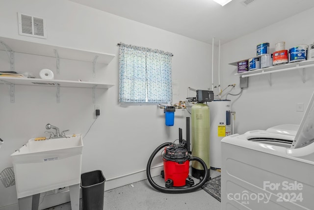 laundry room with sink, water heater, and washer / clothes dryer