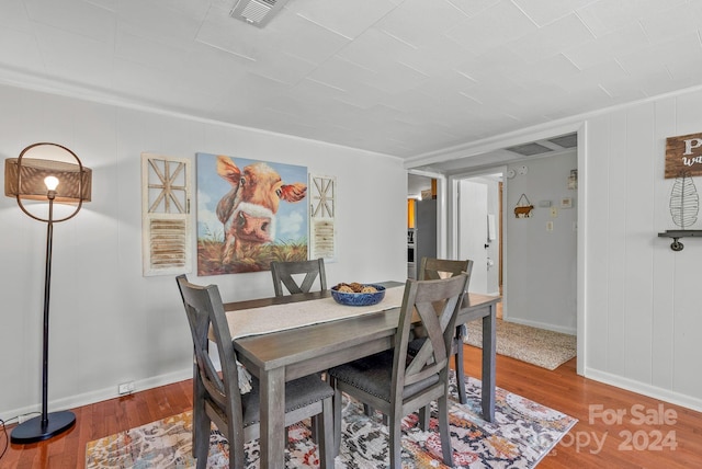 dining area featuring hardwood / wood-style floors and crown molding