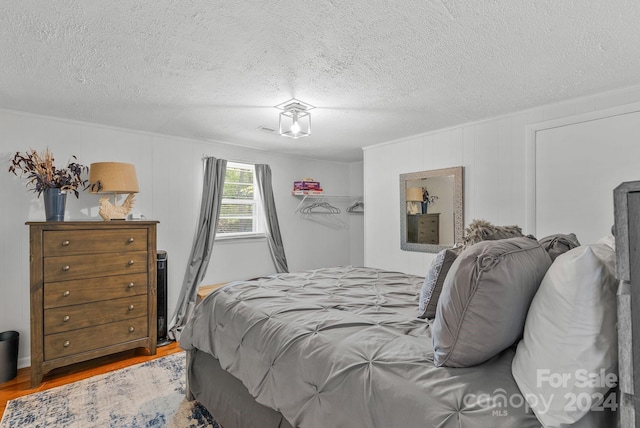 bedroom featuring hardwood / wood-style flooring and a textured ceiling