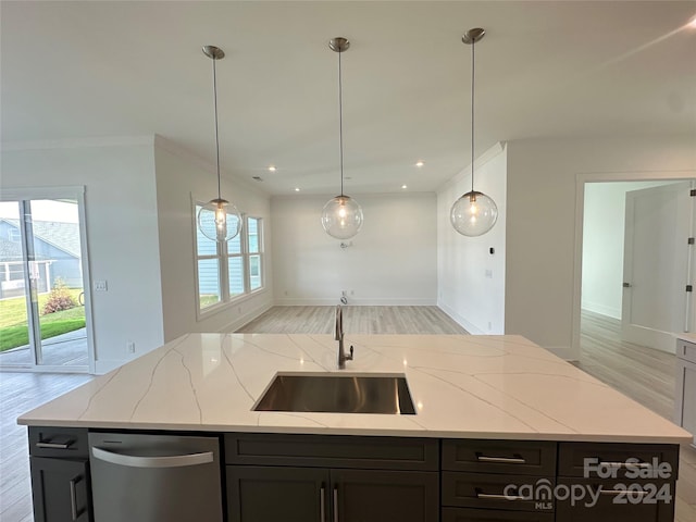 kitchen with light stone countertops, stainless steel dishwasher, sink, a center island with sink, and light hardwood / wood-style floors