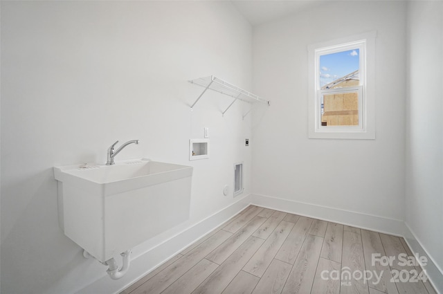 laundry room featuring hookup for a washing machine, light wood-type flooring, electric dryer hookup, and sink