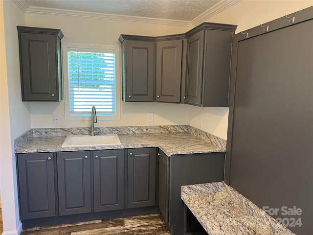 kitchen with ornamental molding, sink, dark hardwood / wood-style flooring, and light stone countertops