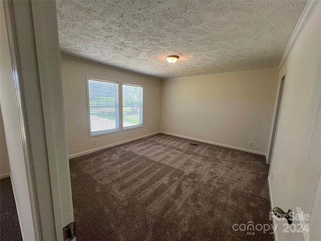 empty room featuring dark carpet and a textured ceiling