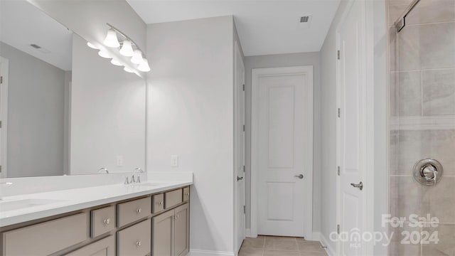 bathroom featuring vanity, tile patterned floors, and a tile shower