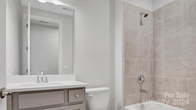 full bathroom featuring toilet, tiled shower / bath combo, and vanity