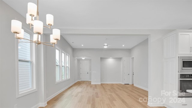 interior space featuring a wealth of natural light, a chandelier, and light wood-type flooring