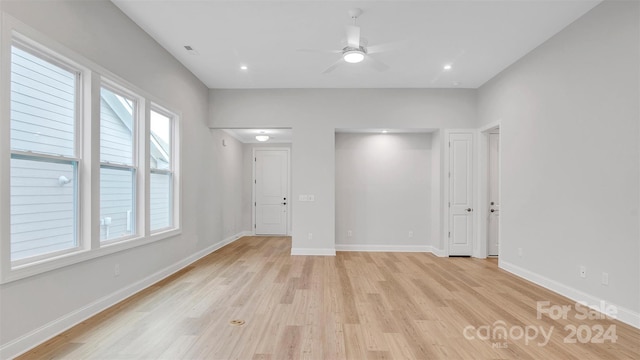 empty room featuring ceiling fan, light wood-type flooring, and plenty of natural light