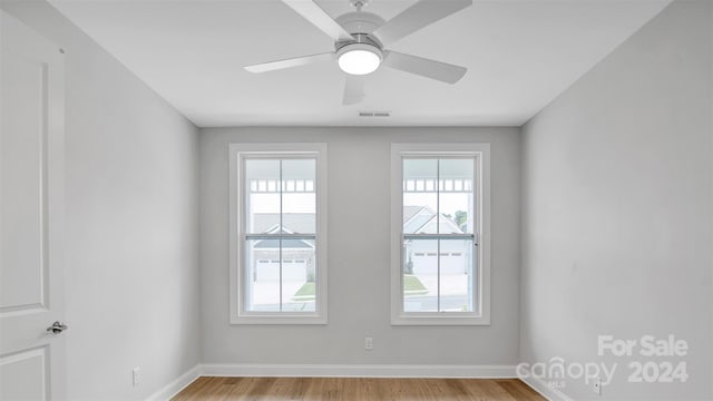 empty room with ceiling fan and light hardwood / wood-style floors