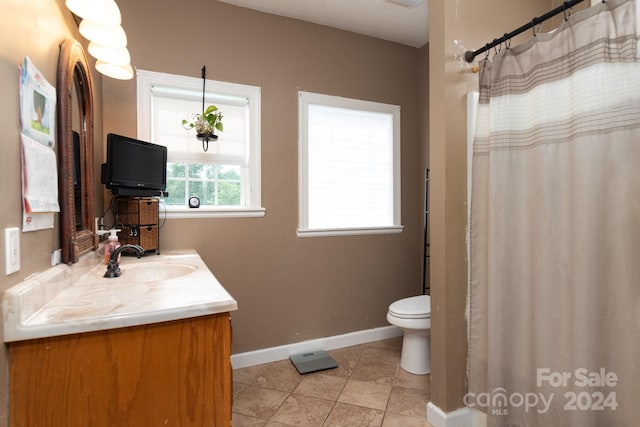 bathroom with toilet, tile floors, and vanity