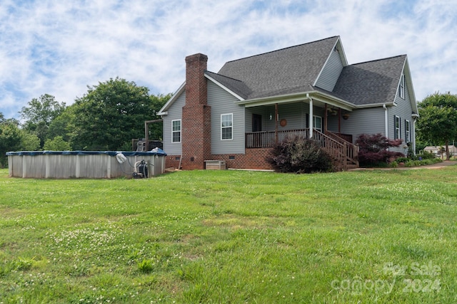 view of property exterior featuring a covered pool and a lawn