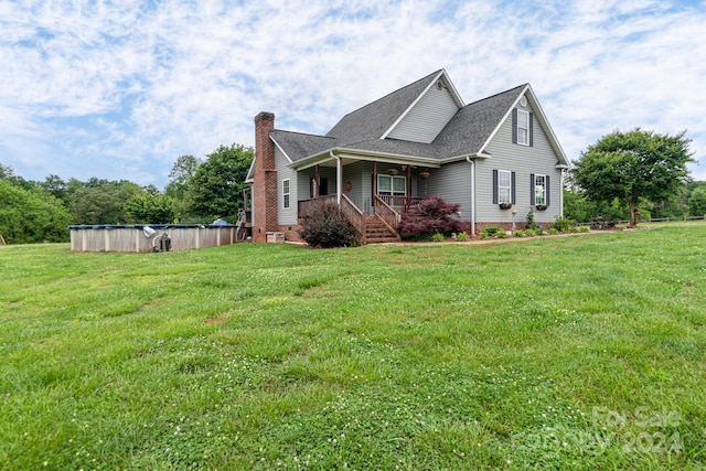 view of side of home featuring covered porch and a lawn