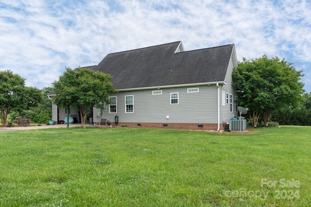 back of house featuring a yard and central air condition unit