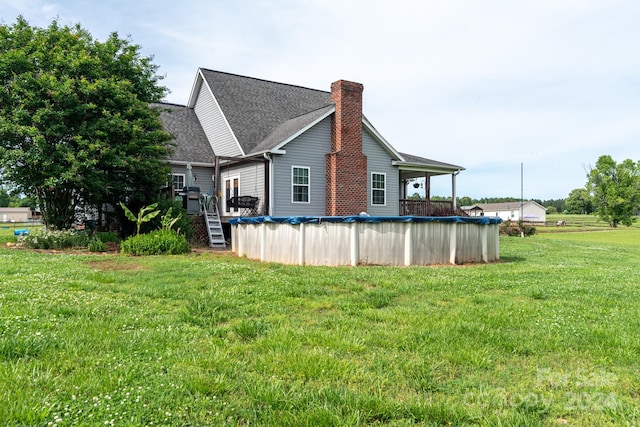 view of side of home with a pool side deck and a lawn