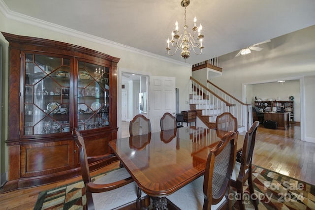 dining area featuring ceiling fan with notable chandelier, hardwood / wood-style floors, and crown molding