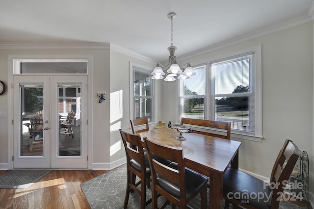 dining area featuring french doors, a notable chandelier, crown molding, and light wood-type flooring