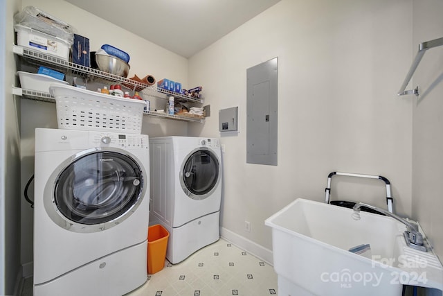 clothes washing area with sink, washing machine and dryer, and light tile floors