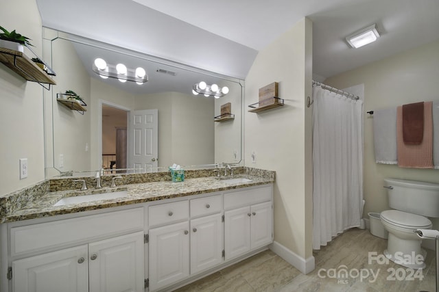 bathroom with tile floors, toilet, and double sink vanity