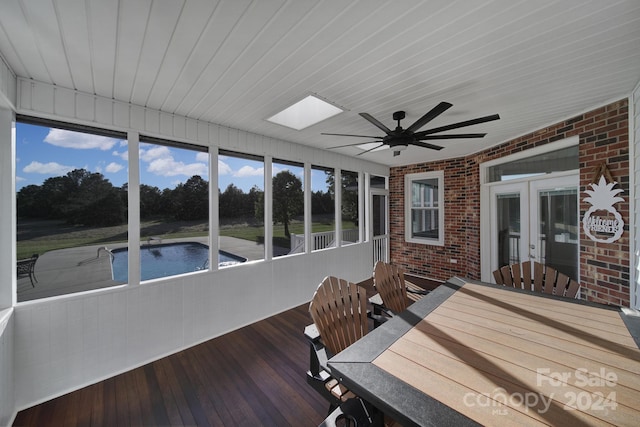 unfurnished sunroom with a skylight and ceiling fan