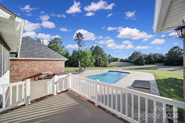 view of pool with a patio area and a lawn