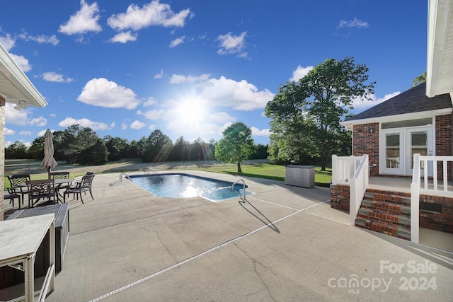 view of swimming pool featuring pool water feature, french doors, and a patio