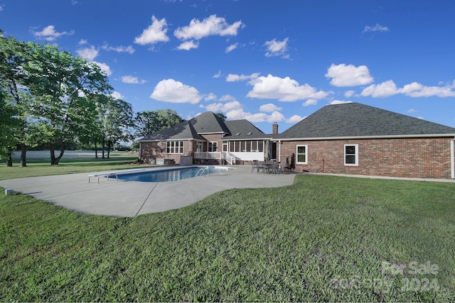 view of swimming pool with a diving board, a patio, and a lawn