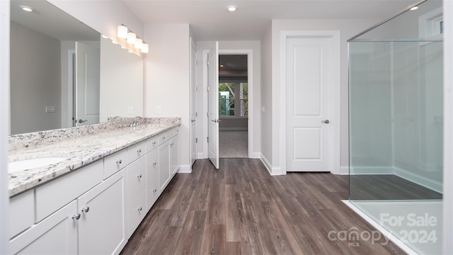 bathroom featuring a shower, vanity, and hardwood / wood-style flooring