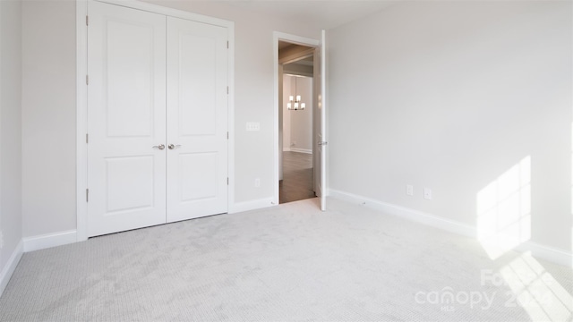 unfurnished bedroom with a closet and light colored carpet