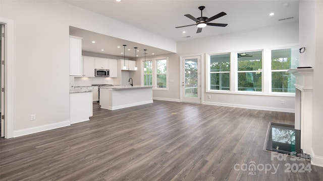 unfurnished living room featuring dark hardwood / wood-style flooring, sink, and ceiling fan