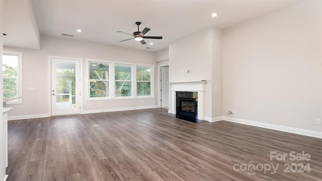 unfurnished living room featuring ceiling fan and dark hardwood / wood-style floors