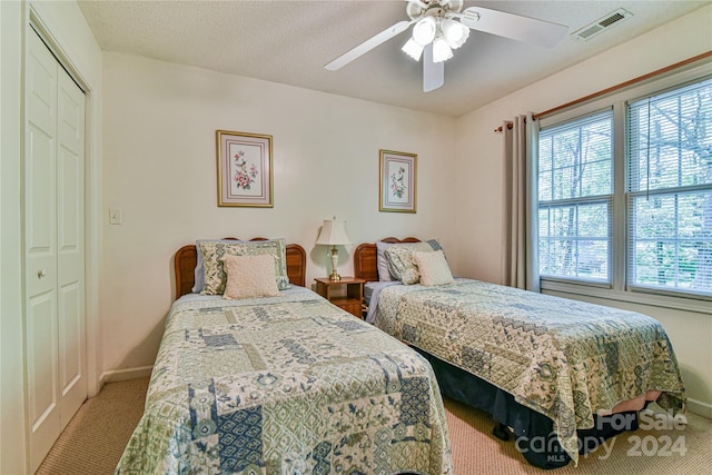 bedroom with carpet, ceiling fan, and a closet