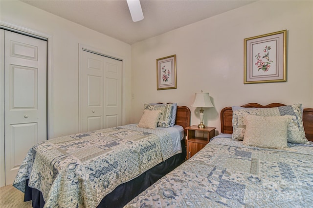 bedroom with ceiling fan and multiple closets